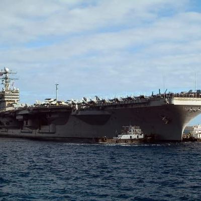 Two tug boats help to move the aircraft carrier USS Carl Vinson Poster Print by Stocktrek Images (34 x 22)